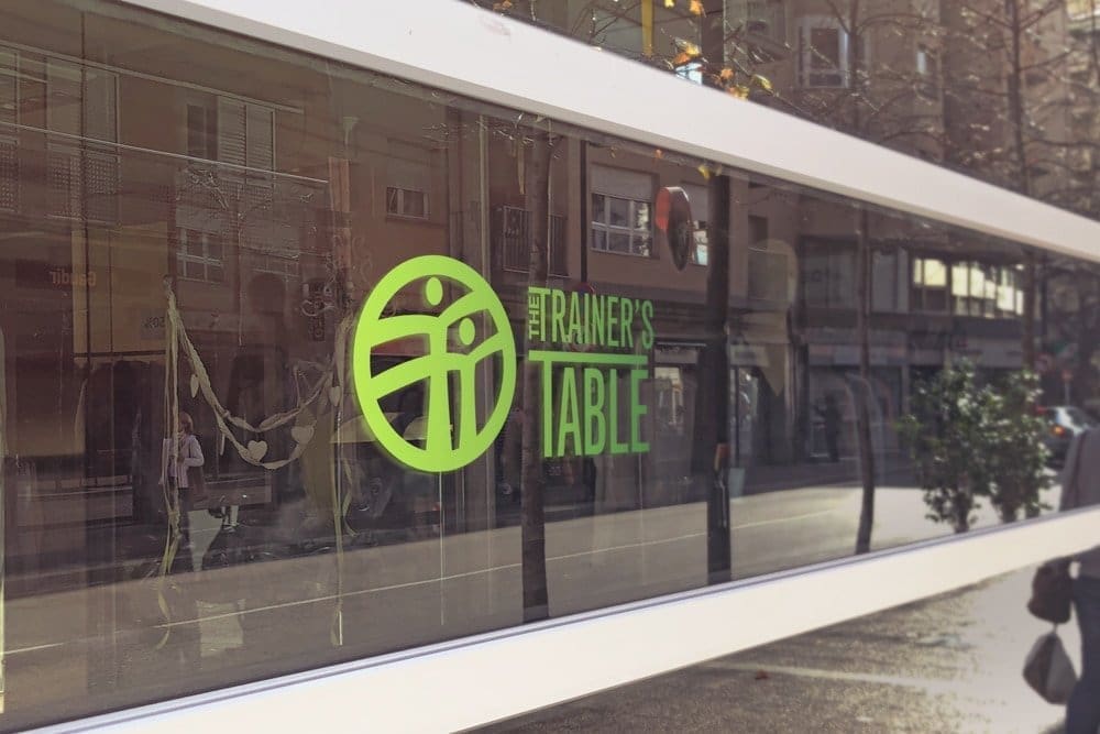 Trainer's table logo design in gradient paint on glass windows